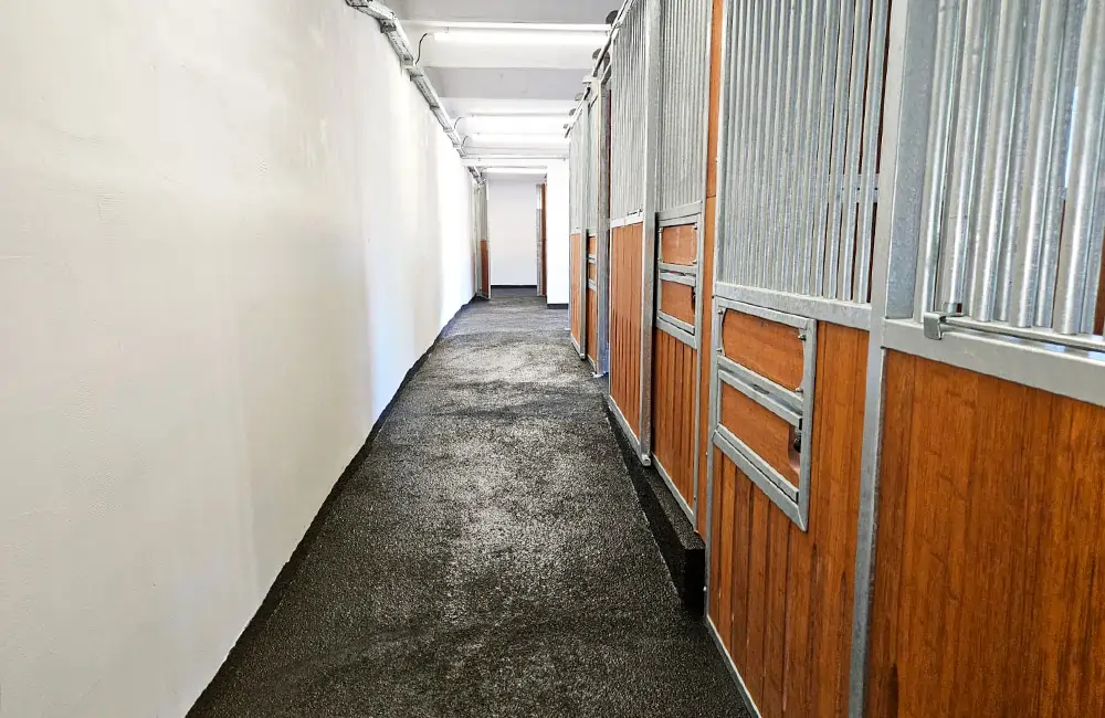 Mit Flüssiggummi beschichteter Stallboden im Pferdestall